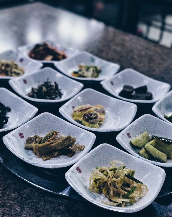 Close-up view of Korean side dishes, beautifully arranged on a table, highlighting traditional cuisine.